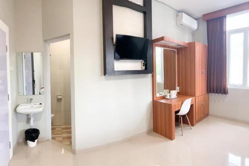 ein Badezimmer mit einem Waschbecken, einem WC und einem Spiegel in der Unterkunft Privato Suite in Kembaran