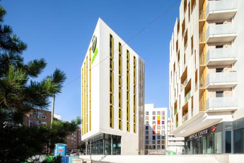 a tall white building with a sign on it at B&B HOTEL Paris Porte de Bagnolet in Bagnolet