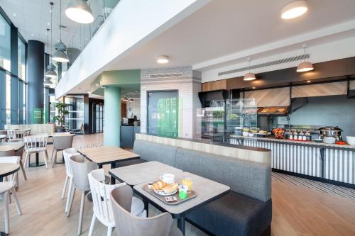 a restaurant with tables and chairs and a counter at B&B HOTEL Paris Porte de Bagnolet in Bagnolet