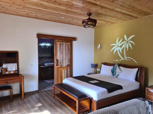 1 dormitorio con cama y techo de madera en La Digue Luxury Beach & Spa, en La Digue