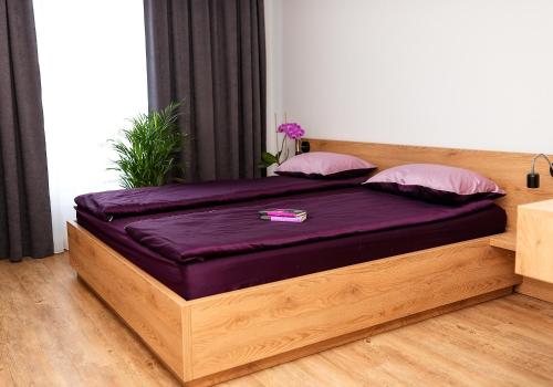 a bed with purple sheets and pillows in a room at VIP Apartamenty number 6 in Lublin