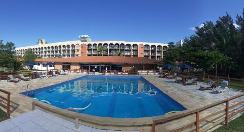 a large pool in front of a hotel at Ravena Cassino Hotel in Laguna
