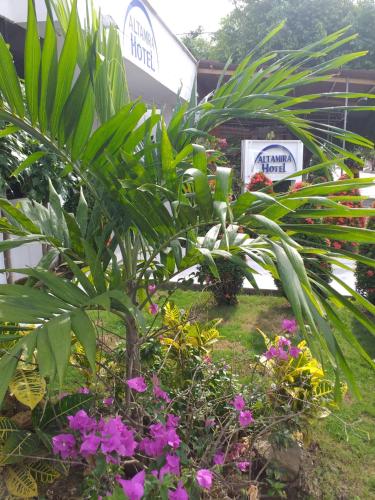 um jardim com plantas e flores em frente a um edifício em Altamira Hotel em Montería