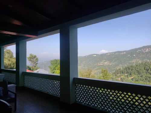 una camera con tre finestre con vista sulle montagne di Mountain View House a Murree