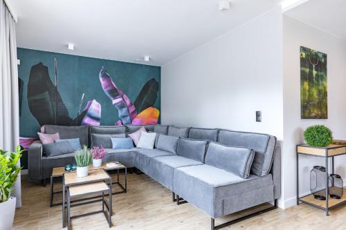 a living room with a couch and a painting on the wall at Śnieżka Exclusive Apartamenty in Kowary