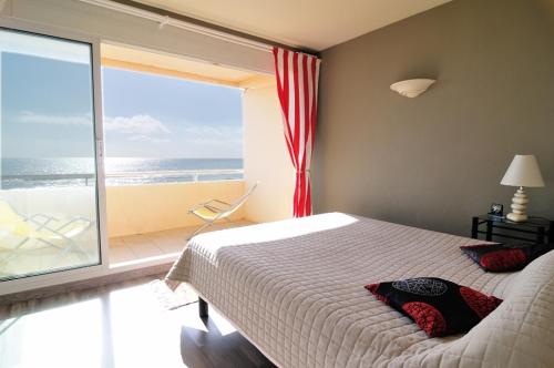 1 dormitorio con cama y vistas al océano en Appartement Estaque, en Valras-Plage