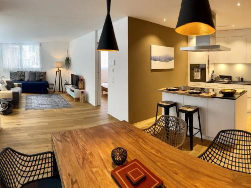 Il comprend un salon et une cuisine avec une table et des chaises en bois. dans l'établissement Apartment SnowKaya by Interhome, à Engelberg