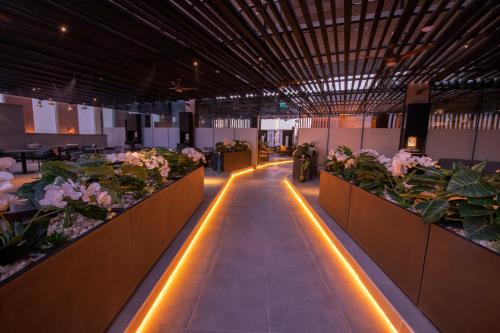 a hallway with flowers and lights in a building at Ascott Rafal Olaya Riyadh in Riyadh