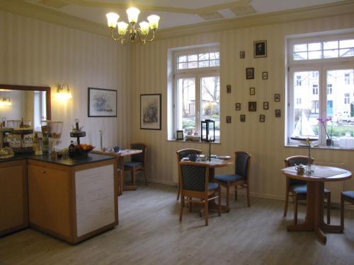 ein Wartezimmer mit Tischen, Stühlen und Fenstern in der Unterkunft Hotel Willert in Wismar