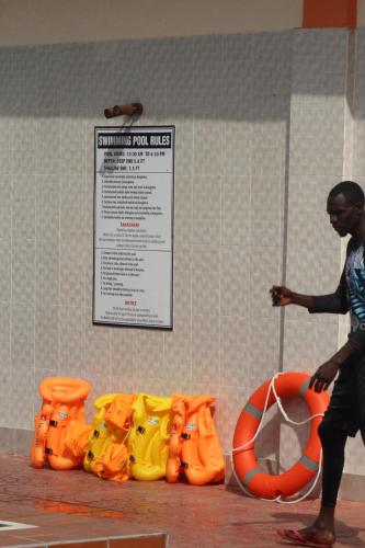 a man walking past a row of inflatableoses at Jakicha Motel in Dar es Salaam