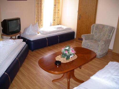 オッフェンバッハにあるホテル ガルニ デャーランのベッド2台、テーブル、椅子が備わる客室です。