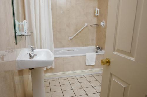 ein Badezimmer mit einem Waschbecken und einer Badewanne in der Unterkunft Leens Hotel in Abbeyfeale