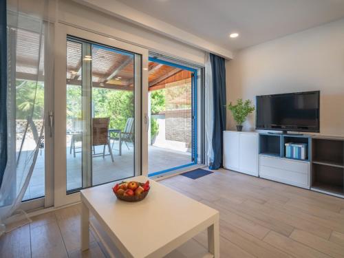a living room with a television and a table at Holiday Home Natali by Interhome in Njivice