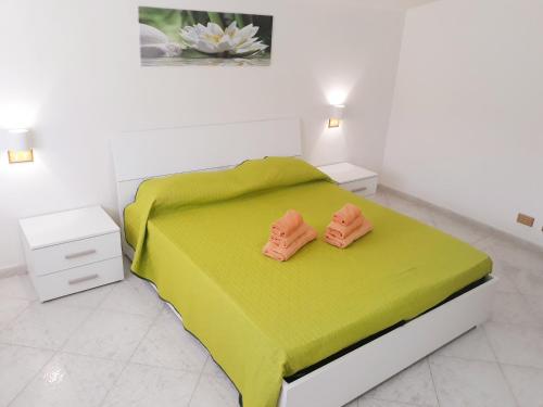 - une chambre avec un lit vert et 2 tables de chevet dans l'établissement Il Narciso, à Bosa