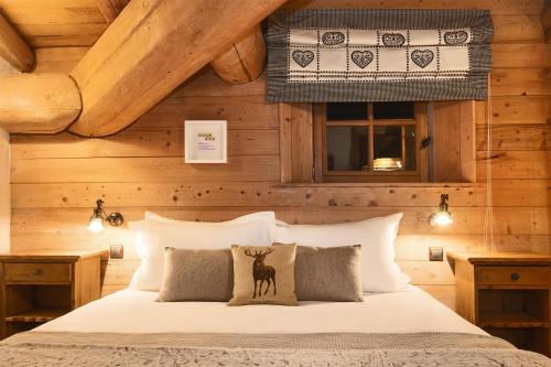 1 dormitorio con 1 cama con paredes de madera en Madame Vacances Le Chalet Arosa en Le Joseray