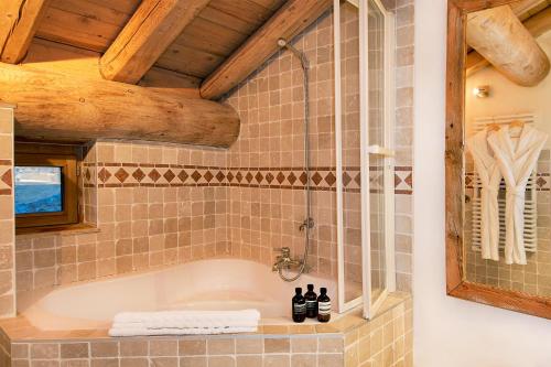 Habitación con baño con bañera. en Madame Vacances Le Chalet Arosa en Le Joseray
