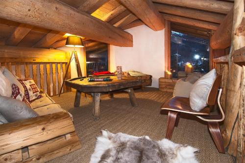 - un salon avec un canapé et une table dans une cabine dans l'établissement Madame Vacances Le Chalet Arosa, à Val dʼIsère