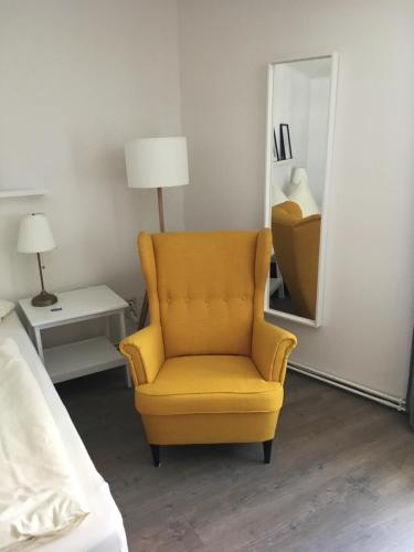 a yellow chair in a room with a mirror at Wohnen am Schloss, Herzog in Sondershausen