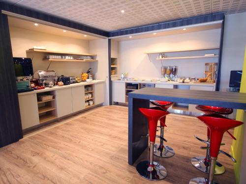 a kitchen area with a stove, sink, and refrigerator at Aparthotel Adagio Nice Promenade des Anglais in Nice