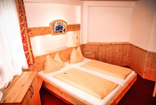 a small bed in a wooden room with a window at Komfort Appartement Royal Windberger in Schladming