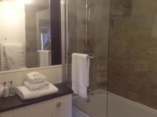 a bathroom with a glass shower with towels on a counter at 3 Braehead in Thurso