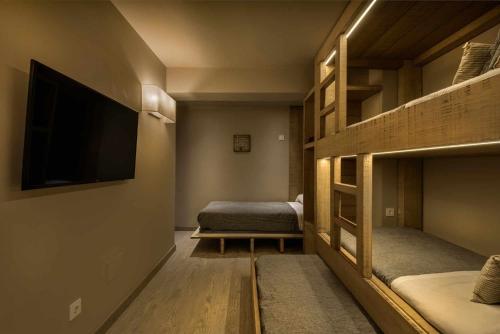 a room with two bunk beds and a flat screen tv at MONTELIA Ático El Ciervo de Panticosa in Panticosa