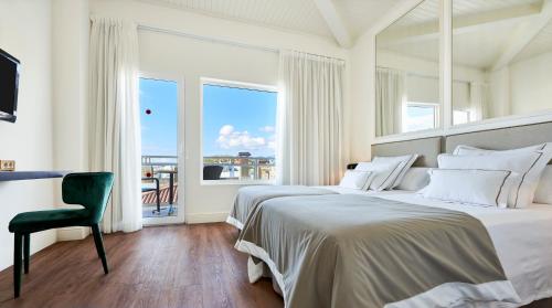 a bedroom with a bed and a desk and a window at Hoposa Daina- Adults Only in Port de Pollensa