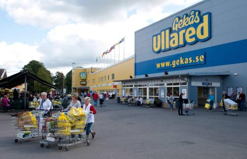 a group of people walking in front of a store at Charmig hallandslänga nära Ullared in Ullared