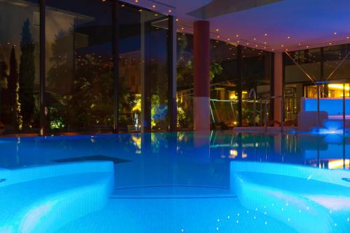 a pool in the middle of a building at night at Villa Nicolli Romantic Spa Resort - Adults Only in Riva del Garda