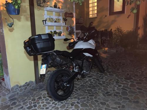 a motorcycle parked next to a wall at B&B Annalu' in Guspini