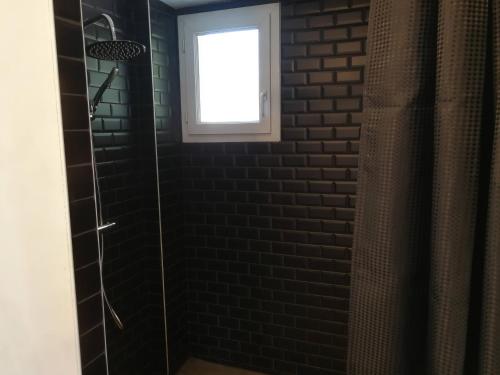 a bathroom with a glass shower with a window at O'Parc du Louet in Mûrs-Érigné