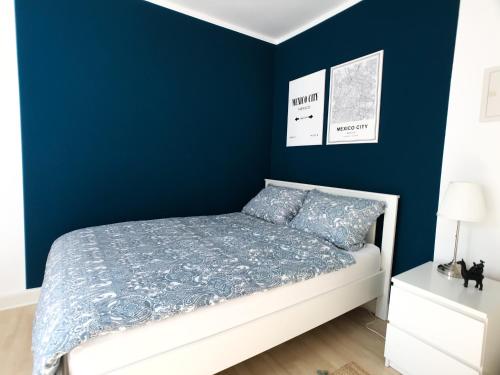 a bedroom with a blue wall and a bed at Dream Green Apartment 'Frida' in Gladenbach
