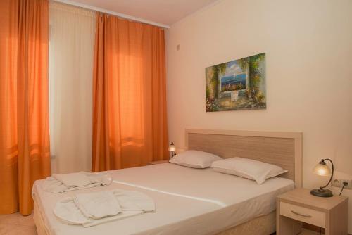 1 dormitorio con 1 cama con 2 toallas en Royal Sun Apartments, en Sunny Beach