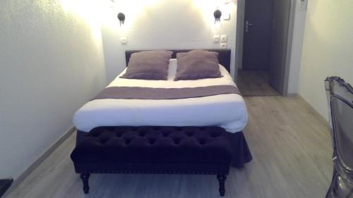 a bed with two pillows on it in a room at Hotel De La Bastide in Carcassonne