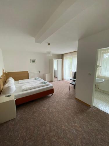 a bedroom with a bed and a chair in a room at Hotel Seehaus in Horn-Bad Meinberg