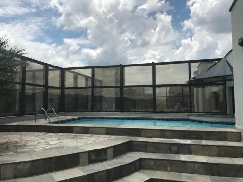 a building with a swimming pool with glass walls at Marsala Apart Hotel in Mogi das Cruzes