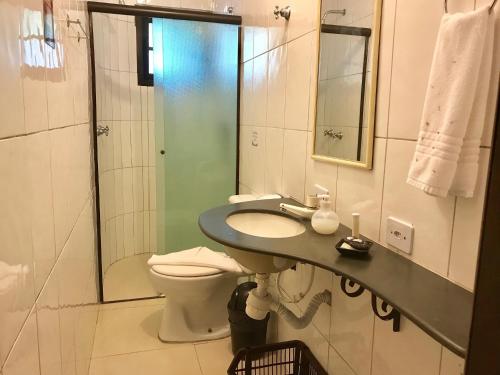 een badkamer met een wastafel, een toilet en een douche bij Hotel Pousada Katmandu in Maresias