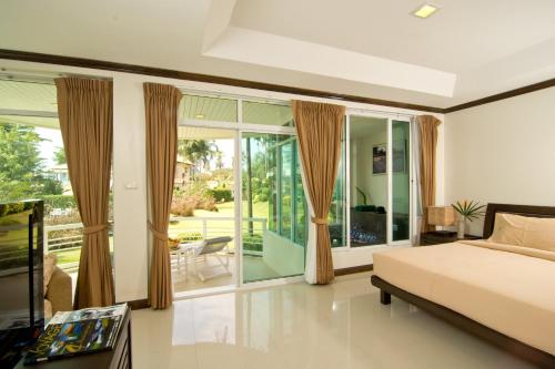 a bedroom with a bed and a large window at Makathanee Resort in Ko Mak