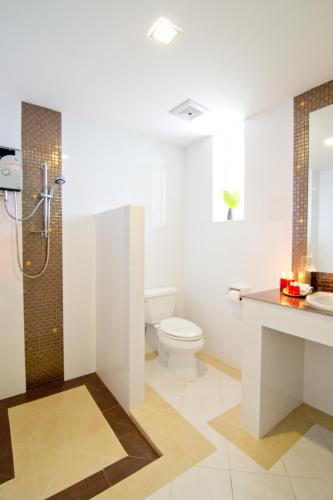 a bathroom with a toilet and a sink and a shower at Makathanee Resort in Ko Mak