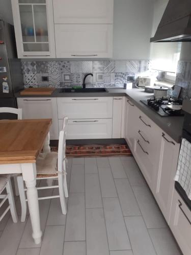 a kitchen with white cabinets and a wooden table at Casa Spina in San Giovanni Teatino