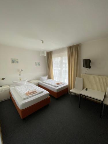 a hotel room with two beds and a television at Hotel Seehaus in Horn-Bad Meinberg