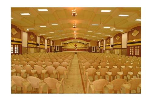 an empty hall with rows of chairs in it at Hotel Mayas in Tiruchchirāppalli