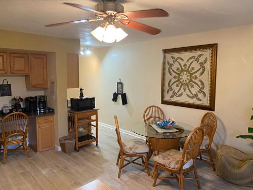 a kitchen and dining room with a table and a ceiling fan at Nani Kai Hale in Kihei