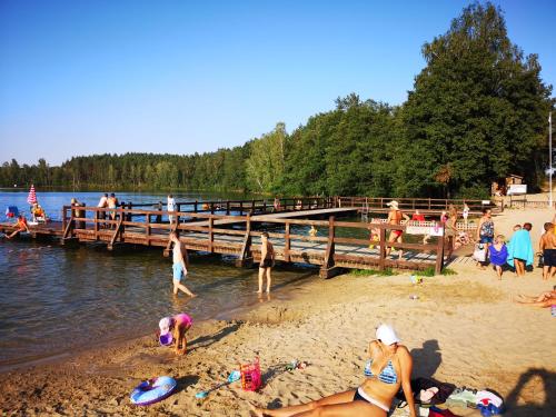 a group of people on a beach near a pier at Domek u Lipków na Kaszubach "Iga" JACUZZI in Lipusz