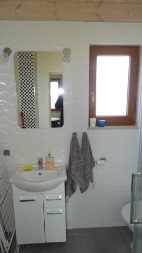 a white bathroom with a sink and a mirror at Domek u Lipków na Kaszubach "Iga" JACUZZI in Lipusz