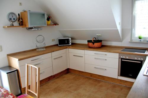 ツィノヴィッツにあるFerienwohnung Zinnowitz USE 2571の白いキャビネット、シンク、電子レンジ付きのキッチンが備わります。
