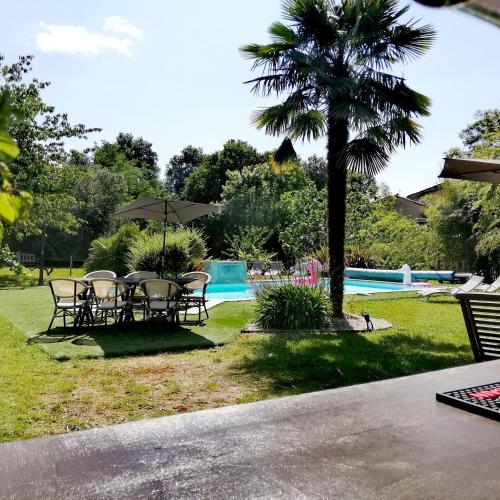 un groupe de tables et de parasols à côté d'une piscine dans l'établissement La Verrerie, à Gaillac