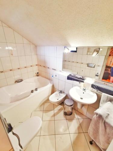 e bagno con vasca, 2 lavandini e vasca. di Apartman Poirot Balcony a Érd