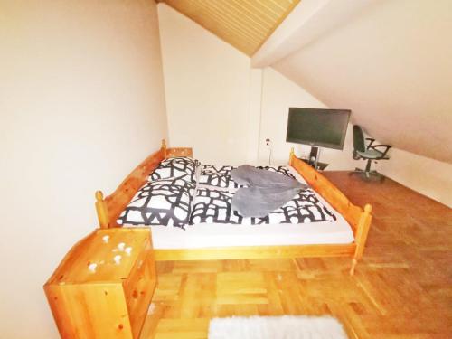 1 dormitorio con 1 cama y escritorio con TV en Apartman Poirot Balcony en Érd