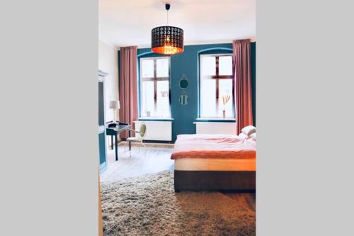 1 dormitorio con cama y pared azul en Villa Rumpel aus Alt mach Neu, en Beeskow